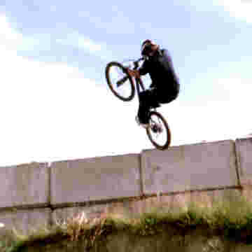 Pros du bike faisant des sauts dangereux en montagne