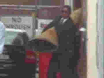 Deux hommes portant un cadavre en pleine journée